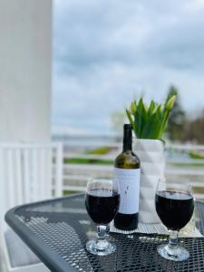 two glasses of wine on a table with a bottle of wine at Fewo-Exklusiv "Seeblick" in Großräschen +9 photos