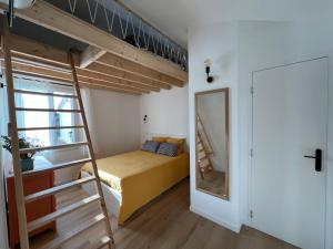 a bedroom with a bunk bed and a ladder at Paisible gîte moderne avec vue sur le Luberon in La Motte-dʼAigues