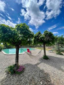 una hamaca entre dos árboles y una piscina en Villa à flanc de colline, en Saint-Ambroix