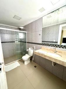 y baño con aseo, lavabo y espejo. en Pousada Eu Amo Arraial, en Arraial do Cabo