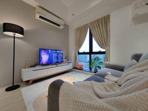 ein Wohnzimmer mit einem Sofa und einem Flachbild-TV in der Unterkunft Cozy 2bedroom # Revo Bukit Jalil #Pavillion 2 in Kuala Lumpur