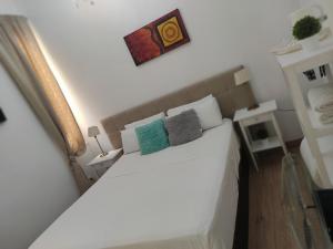 um quarto com uma cama branca e 2 almofadas em Grand Via House em Madri