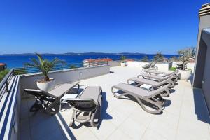 a row of lounge chairs on the roof of a building at Luxury Home Polo in Bibinje