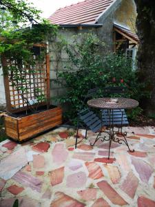 een tafel en stoelen op een stenen patio bij Villa le Cloky in Thomery