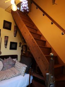 a bedroom with a bed and a wooden staircase at Villa le Cloky in Thomery