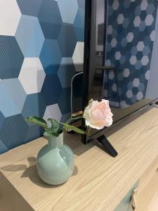 un vaso con una rosa sul tavolo di L’azur au centre de Vitré et proche château/gare a Vitré