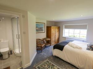 a bedroom with a bed and a bathroom with a shower at Moon Field Lodge in Scunthorpe