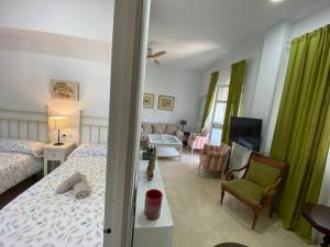 a bedroom with a bed and a living room at Apartamento Crucero 1, La Jara in Sanlúcar de Barrameda
