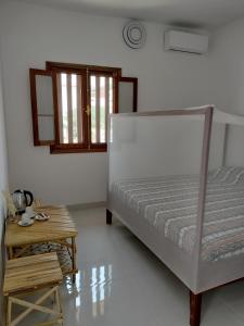 1 dormitorio con cama y mesa de madera en Ker Vento, en Rufisque