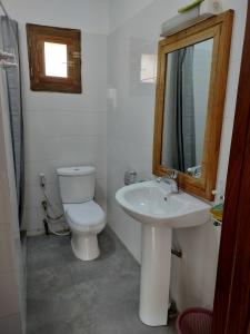 a bathroom with a toilet and a sink and a mirror at Ker Vento in Rufisque