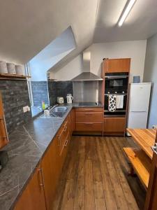 a kitchen with wooden cabinets and a counter top at The Mews Holiday Let in Tillicoultry