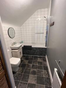a bathroom with a toilet and a tub and a sink at The Mews Holiday Let in Tillicoultry