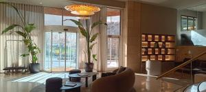 una sala de estar con macetas y una lámpara de araña. en Best Western Premier CMC Girona en Girona