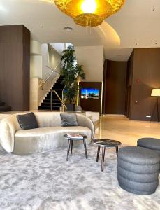 a living room with a couch and two tables at Best Western Premier CMC Girona in Girona