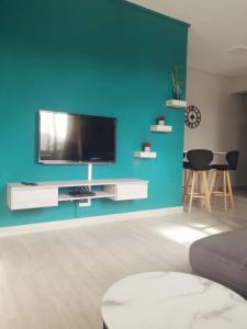a living room with a blue wall with a flat screen tv at Enjoy Paradise Newave Holiday - Appartment No 8 in Flic-en-Flac