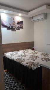 um quarto com uma cama e um quadro na parede em Apartamento inteiro litoral norte Natal RN em Natal