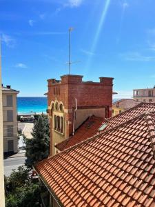 a red brick building with the ocean in the background at La Casa Del Molo in Finale Ligure