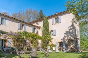a large white building with chairs and trees at Bastide de 400m² à Aix in Aix-en-Provence