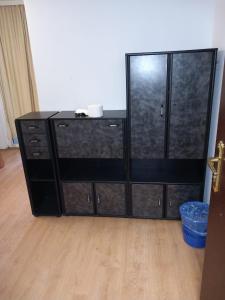 a black dresser in a room with a wooden floor at HOSTEL WIEN in Barakovići