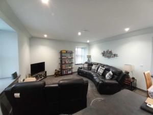 a living room with a leather couch and a television at 19a Francis Street in Stornoway