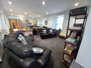 a living room with a leather couch and a table at 19a Francis Street in Stornoway