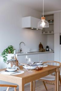 einen Holztisch mit Tellern und Gläsern darauf in der Küche in der Unterkunft Comfortable apartment near the sea in Knokke-Heist