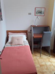 Habitación pequeña con cama y escritorio. en MERIDIAN HOUSE LECCO, en Lecco
