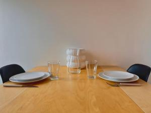 第戎的住宿－Le Néon Dijonnais，一张木桌,上面有盘子和玻璃杯