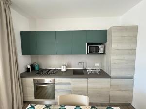 a kitchen with green cabinets and a sink at Villa Capri by Sicilvill in Campofelice di Roccella
