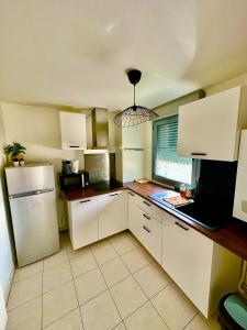 a kitchen with white cabinets and a refrigerator at Elegant apartment Paris Bagnolet 303 in Bagnolet