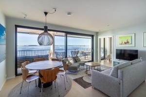 a living room with a dining table and a view of the ocean at Hanko Kuningatarranta Apartment in Hanko