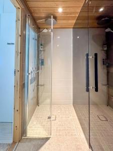 a shower with a glass door in a bathroom at Hanko Kuningatarranta Apartment in Hanko
