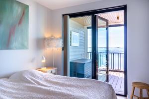 a bedroom with a bed and a balcony at Hanko Kuningatarranta Apartment in Hanko