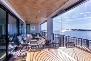 a balcony with chairs and a view of the water at Hanko Kuningatarranta Apartment in Hanko