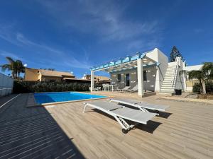 een huis met een zwembad en een zwembadvisor bij Villa Capri by Sicilvill in Campofelice di Roccella