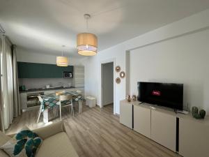 een woonkamer met een televisie en een eetkamer bij Villa Capri by Sicilvill in Campofelice di Roccella