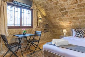 a bedroom with a bed and a table and chairs at Timberwood Studio in Batroun in Batroûn