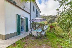 a patio with a table and chairs and an umbrella at Casa Annameri in Marciana