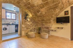 a living room with a stone wall and a tv at Timberwood Studio in Batroun in Batroûn