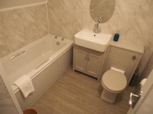 a bathroom with a tub and a sink and a toilet at The Pavilion Bisley in Bisley