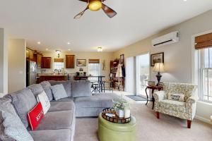 a living room with a gray couch and a kitchen at Ruftop Ridge in Hammondsport