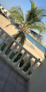 einen Balkon mit Palmen und Strand in der Unterkunft Al Ahlam Island Villa Durrat AlArous فيلا جزيرة الأحلام درة العروس in Durrat Al-Arus