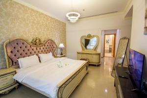 Wonderful Master Rooms For Girls ONLY in Marina, Dubai في دبي: غرفة نوم بسرير كبير وتلفزيون بشاشة مسطحة