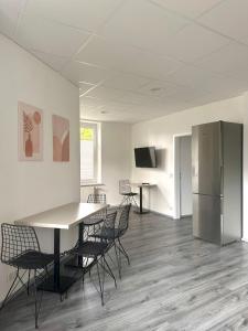 a room with a table and chairs and a refrigerator at Craftsmen´s Comfort - Apartment by Comfort Housing in Falkensee