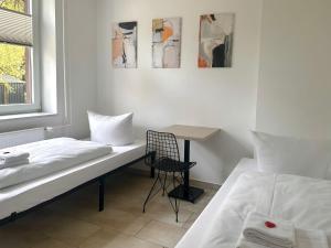 a bedroom with a bed and a table and a chair at Craftsmen´s Comfort - Apartment by Comfort Housing in Falkensee