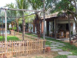 une maison avec une clôture devant une cour dans l'établissement Home Farm Villa Hoi An, à Hội An