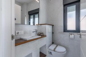 a bathroom with a toilet and a sink and a mirror at Vinos & Vinilos by Ĥ in Ayamonte