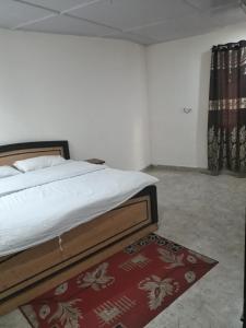 1 dormitorio con cama y alfombra roja en 0 point home stay Mussoorie, en Mussoorie