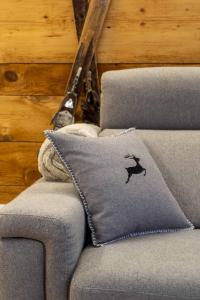 eine graue Couch mit einem Kissen mit einem Vogel drauf in der Unterkunft Casa Graziosa in Campodolcino