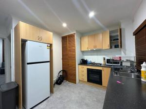 a kitchen with a white refrigerator and a sink at Remarkable 2 Bedroom House at the Centre of Darlinghurst in Sydney